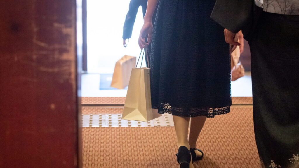 引き出物の紙袋を持って帰るゲスト